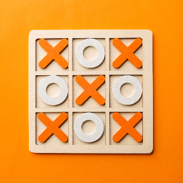 In this example, we make the wooden table transparent in a BMP photo of a tic-tac-toe board game. The wooden X pieces have almost the same orange color as the table surface, so regular color removal would also erase parts of the game. To avoid that, we enable the option that clears only matching border-connected areas. With 36% color matching, the surrounding table becomes transparent, while the tic-tac-toe pieces stay visible. (Source: Vecteezy.com.)